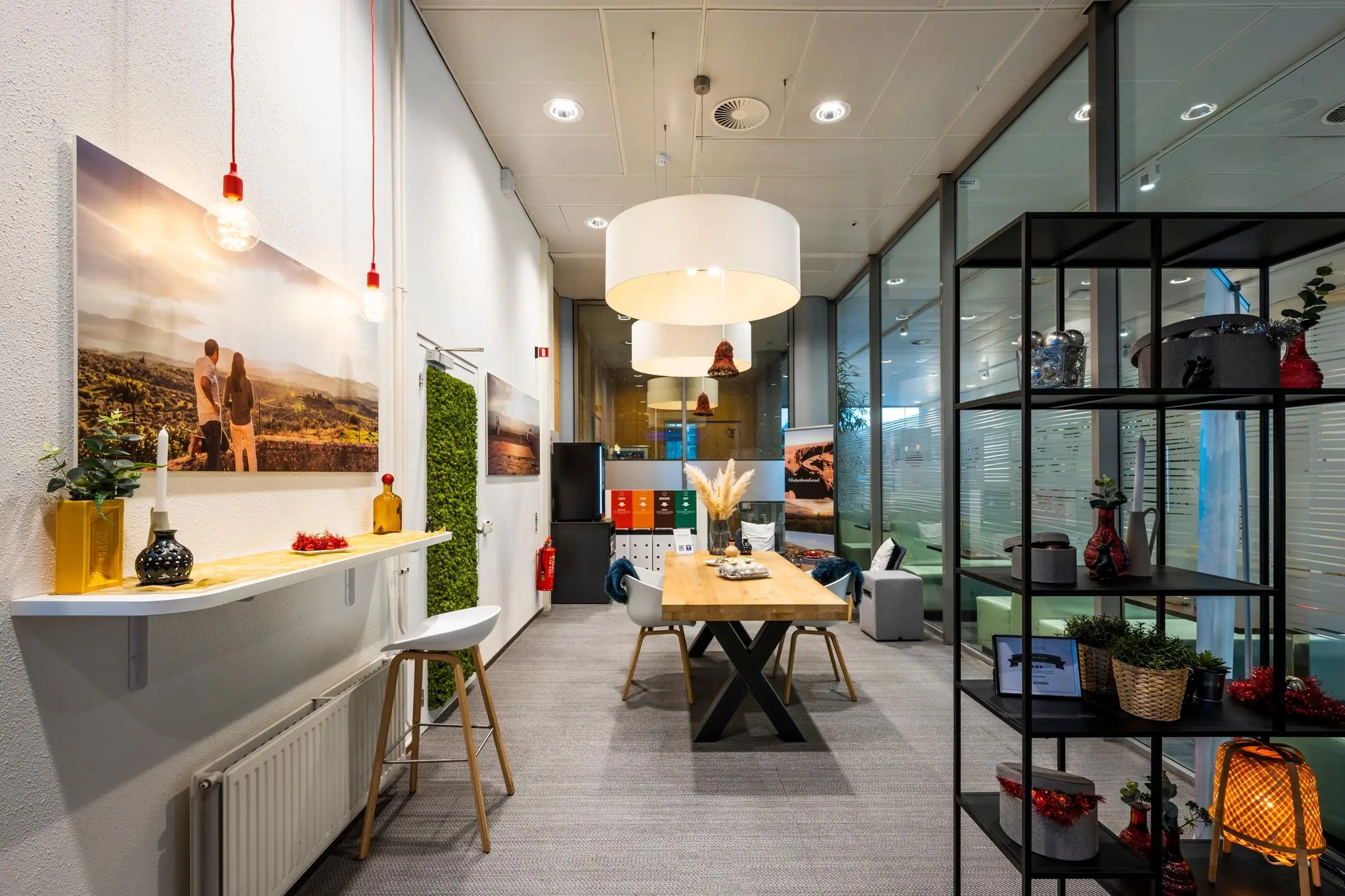 Modern ingericht kantoor aan de Burgemeester Rijnderslaan met houten tafel, decoratieve rekken en sfeervolle verlichting.